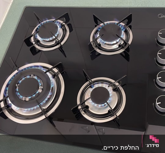 כיריים גז עם ארבעה מבערים דולקים
